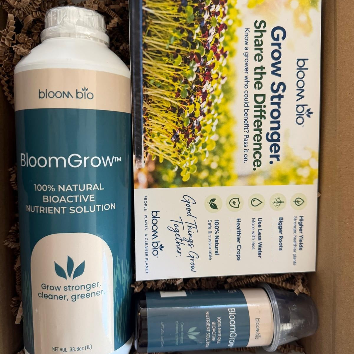 BloomGrow 1 L bottle with a sample bottle and Grow Stronger card, packed in the shipping box